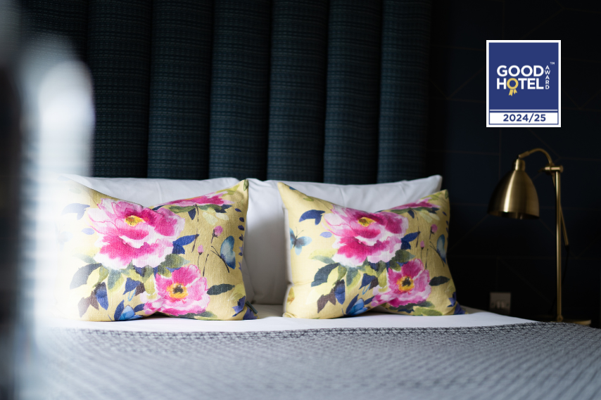 Elegant Clandeboye Lodge hotel bedroom with floral cushions and Good Hotel Award 2024/25 badge – boutique accommodation in Bangor, Northern Ireland.