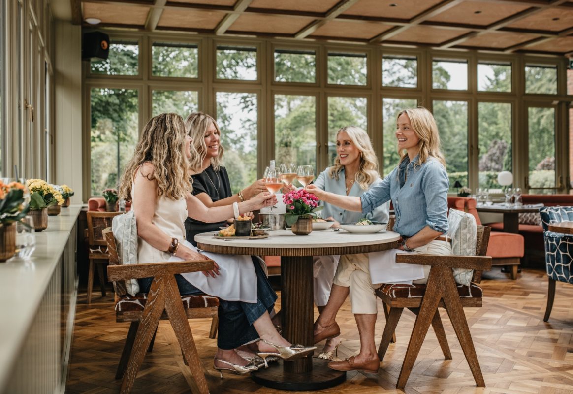 Friends dining together in the Garden Room at Coq & Bull