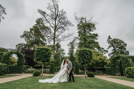 Bride and groom walking through landscaped gardens at Clandeboye Lodge wedding venue in County Down