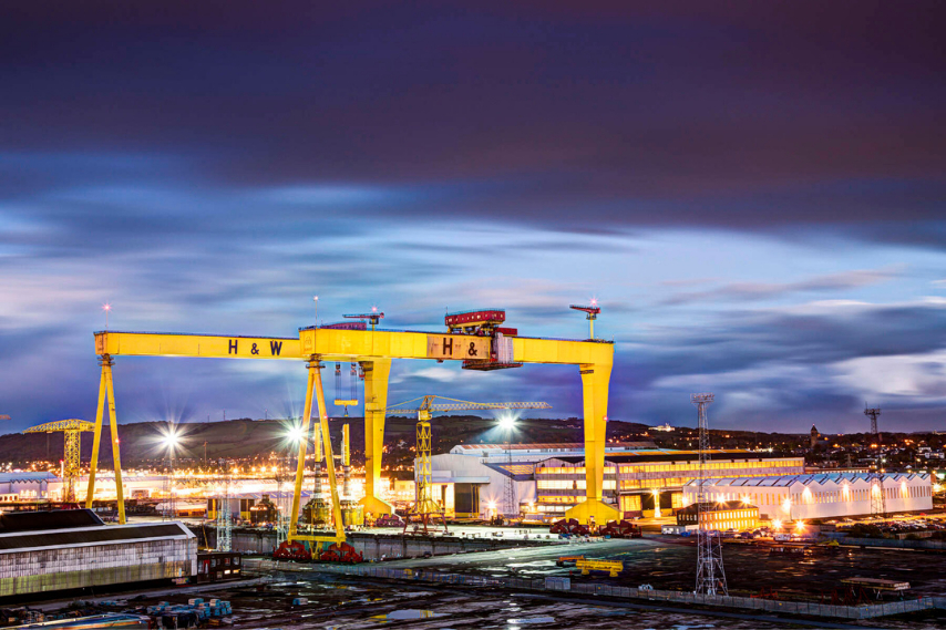 The iconic Harland & Wolff shipyard cranes in Belfast at dusk.