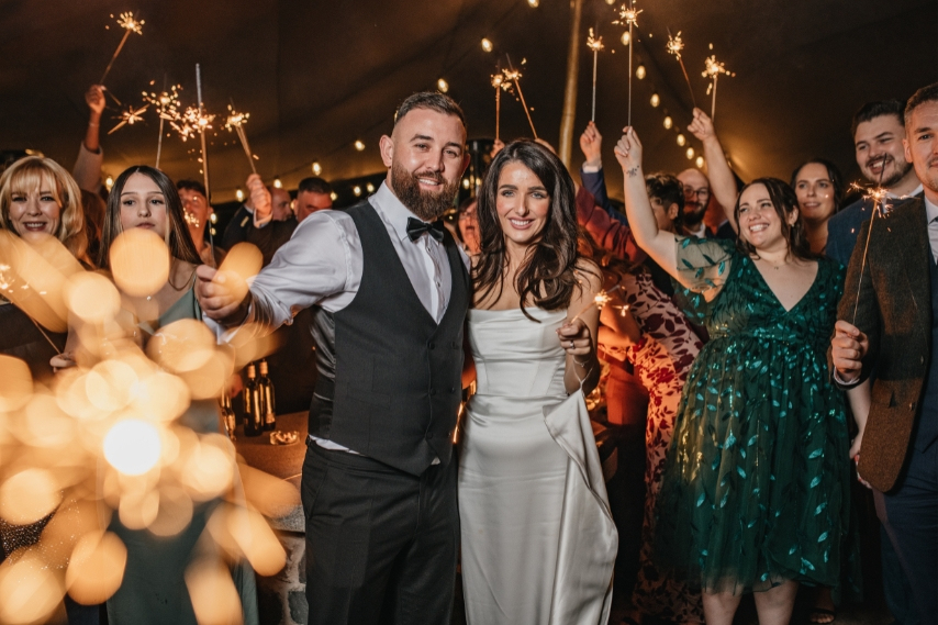 Bride and groom celebrating with wedding guests during an evening reception at Clandeboye Lodge