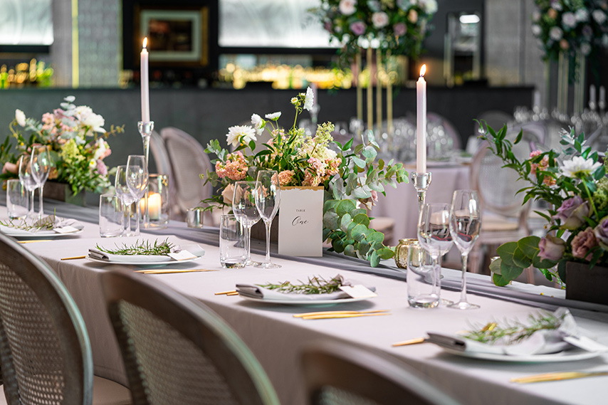 Table setting at wedding venue in Northern Ireland with flowers, candles and glasses.